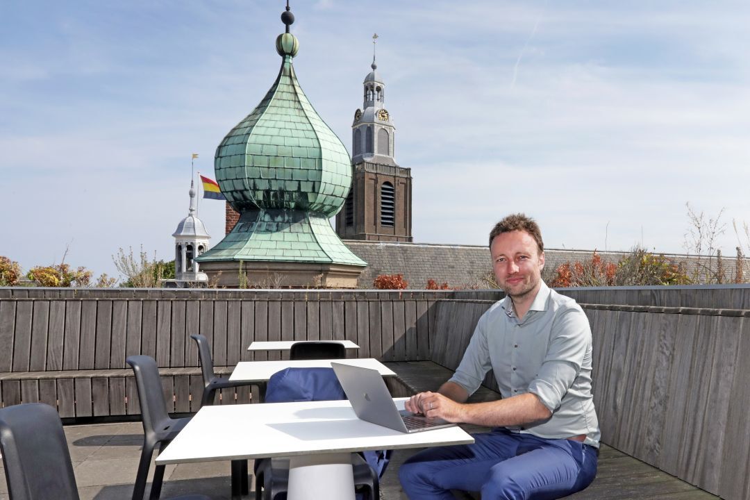 Foto van Wethouder Koen Kegel achter een laptop op het Dakterras van Westnieuwland