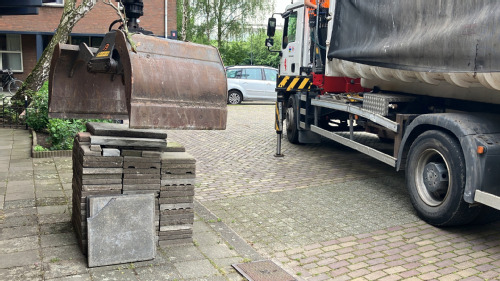 wagen schept stapel tegels op