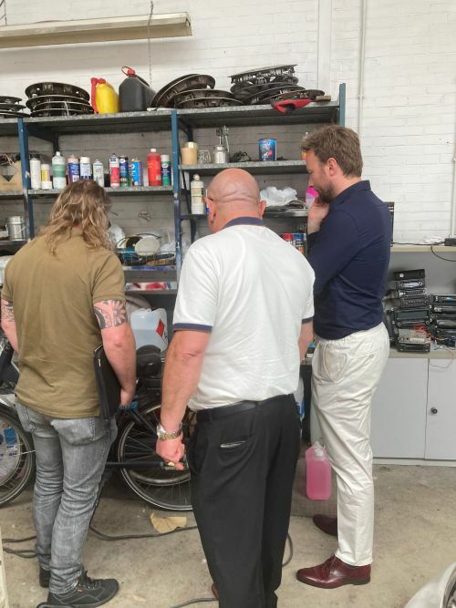 Foto van wethouder Koen Kegel op bezoek bij garage